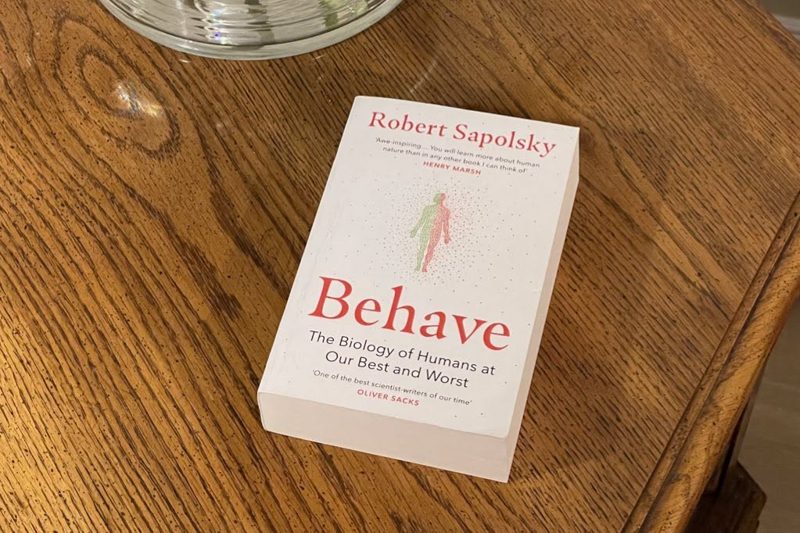 Behave by Robert Sapolsky on a wooden table